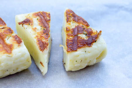 Delicious summer snack. Grilled salted Levantine halloumi cheese on a white plate. Traditional...