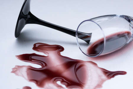 Broken wine glass and spilled wine on a light background. Broken love, depression and hopelessness conceptの写真素材