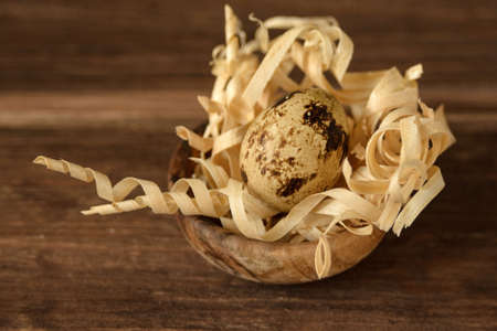 Quail egg on sawdust in a wooden plate. Rustic food. A healthy product and proper nutrition.の写真素材