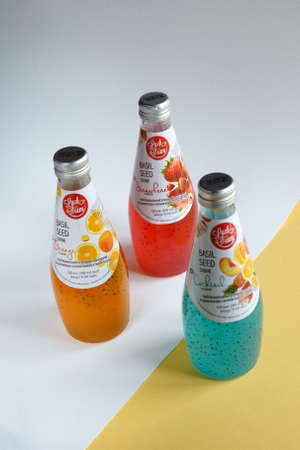 Cherkasy, Ukraine, February 2021. Three bottles of bright drink with Basil Seed on a light...