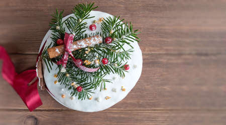 German Christmas cake on wooden table with festive decorations. Dresdnen Stollen is a Traditional German Cake with raisins. Gift for Christmas.の写真素材