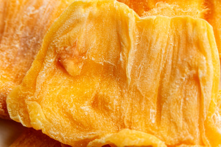 Slices of dried jackfruit. Fruit chips. Useful and tasty snacks. Close-up.