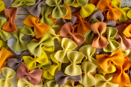 Scattered colorful pasta in the shape of butterflies close-up. Famous traditional Italian farfalle.の写真素材