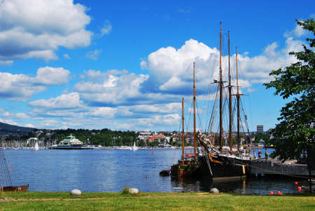 Norway - June 2006: Typical Norwegian landscape. Ships, water, city and beautiful clouds floating across the sky.のeditorial素材