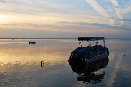 RUSSIA - OCTOBER 2020: Sunset and a lone boat on Lake Pleshcheyevo. Pereslavl Zalessky, Russia.