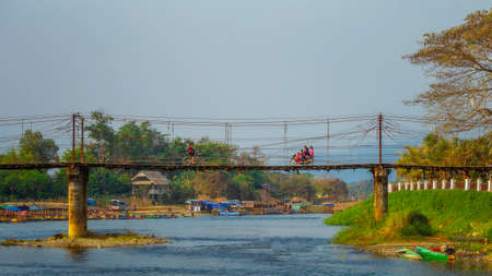 SAKONNAKHON, THAILAND â FEBRUARY 5: Young women and children are walking across a wooden bridge built for crossing a small river on February 5, 2017 in Sakonnakhon, Thailand.のeditorial素材