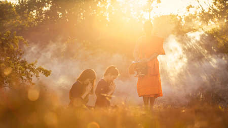 SAKONNAKHON, THAILAND â FEBRUARY 5: Two young Asian women were sitting in the bowl feeding the monks standing in front on February 5, 2017 in Sakonnakhon, Thailand.のeditorial素材