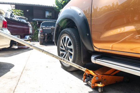 Lift the car with hydraulic floor jack for repairing. Remove wheels to change tires.の写真素材