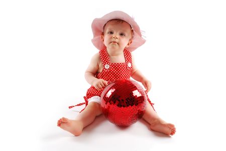Little baby girl in red dress and hat with red ballの写真素材