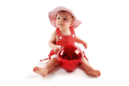 Little baby girl in red dress and hat with red ballの写真素材