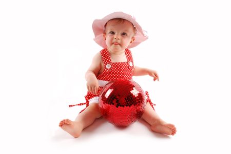 Little baby girl in red dress and hat with red ballの写真素材