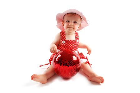 Little baby girl in red dress and hat with red ballの写真素材
