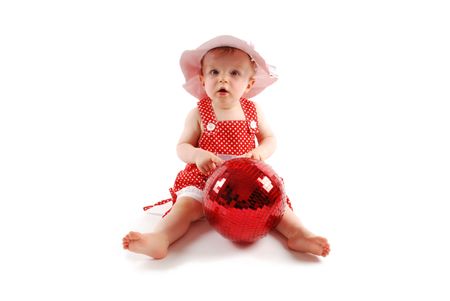 Little baby girl in red dress and hat with red ballの写真素材