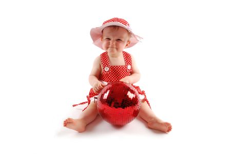 Little baby girl in red dress and hat with red ballの写真素材