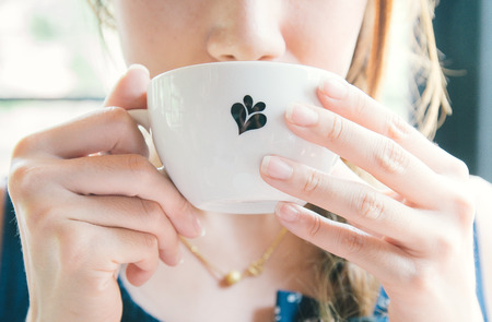 Woman drinking a cup of hot coffeeの写真素材