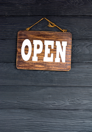 Open text on wooden plate hang on black wooden platesの写真素材