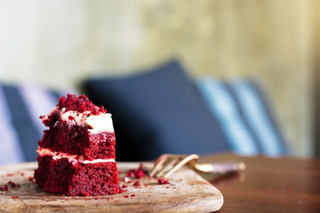 Red velvet cake was chipped on wooden plate with forkの写真素材
