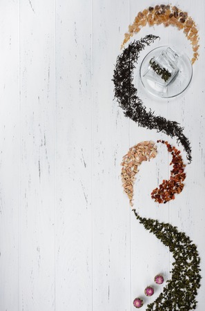 Set of different sorts of tea on white background with a glass cupの写真素材