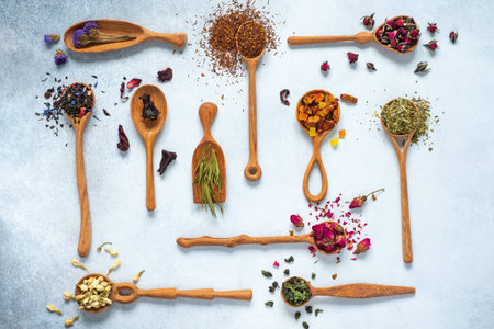 Black, fruit, cornflower, hibiscus, wild rose, white lotus and rooibos tea in wooden spoonsの写真素材