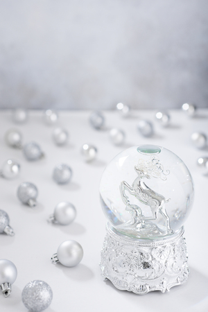 Defocused christmas background with silver christmas water globe and ballsの写真素材