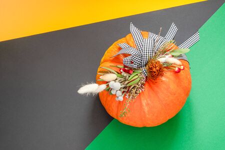 Halloween or Thanksgiving background. Autumn composition in pumpkin with ribbons and dried flowers with copy space.の写真素材
