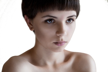 Portrait of a beautiful girl with short hair, brown eyes and bare shoulders serious looking ahead.Short Hair style.Female model isolated white background.の写真素材