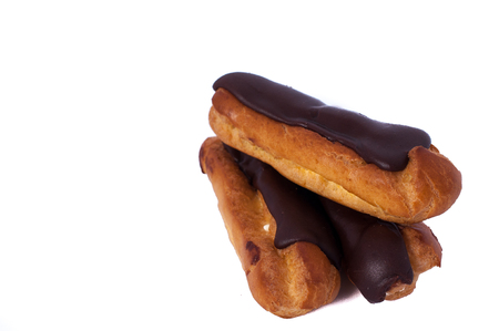 Sweet three chocolate eclairs isolated on white. Traditional french cakes cooked from choux dough filled with a creamの写真素材