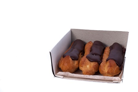 Sweet delicious three chocolate eclairs isolated on white. Traditional french cakes cooked from...