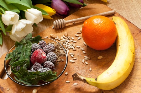 banana, orange,frozen strawberries blackberries and seeds vivid smoothie ingredients on the wooden backgroundの写真素材