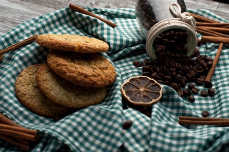 still-life homemade cookies coffee beans, orange slices, cinnamon on wood