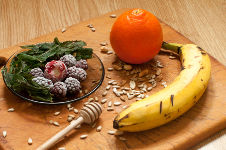 banana, orange,frozen strawberries blackberries and seeds vivid smoothie ingredients on the wooden backgroundの写真素材