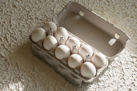 Eggs in the package on white table background