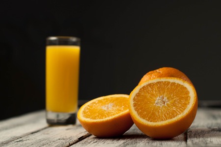 Orange fruit cut and orange juice on wooden table background.の写真素材