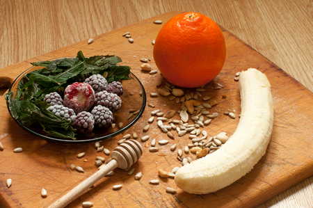 banana, orange,frozen strawberries blackberries and seeds vivid smoothie ingredients on the wooden backgroundの写真素材