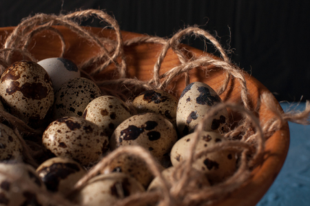quail eggs in wooden bowl isolated on blue background.の写真素材