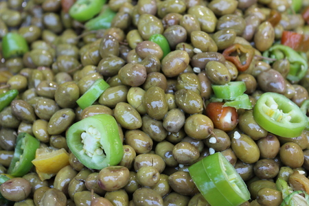 Green olives with green pepper in the marketの写真素材