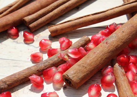 pomegranate seeds and cinnamon on a wooden surface background for Rosh Hashanaの写真素材