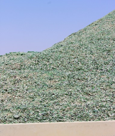 A mountain of small fragments of green glass from broken bottles for recyclingの写真素材