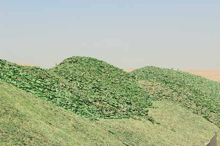 A mountain of small fragments of green glass from broken bottles for recyclingの写真素材