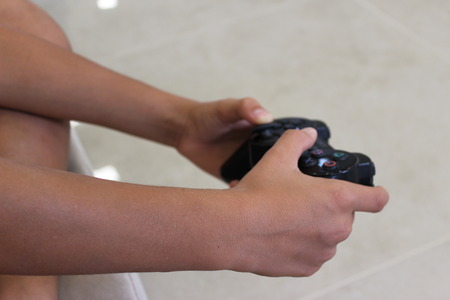 A boy playing video game on console controllerのeditorial素材