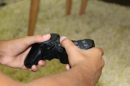 A boy playing video game on console controllerのeditorial素材