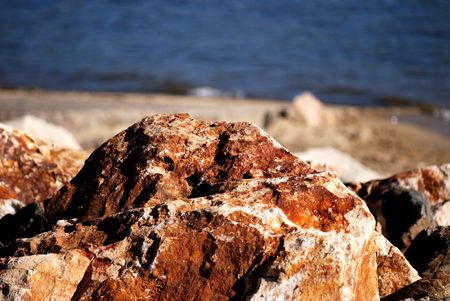 Close up of a rock formation on the shoreline of Big Bear Lake, California.  This photo shows closeup detail of the rocks with the lake blurred in the background.の写真素材