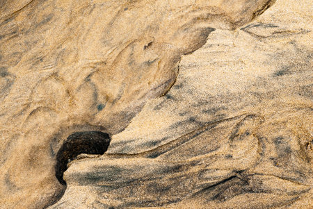 Water and sand form a graphic pattern on a beach in northern Brittanyの写真素材