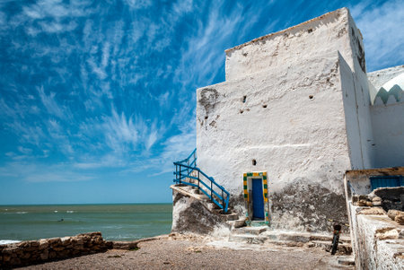 An old decrepit white building faces the sea near the beach of Sidi Kaoukiのeditorial素材