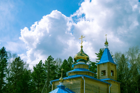 wooden church in the forest, the sky and cloudsの写真素材