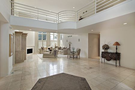 Living room with view of second floor with curved railingの写真素材