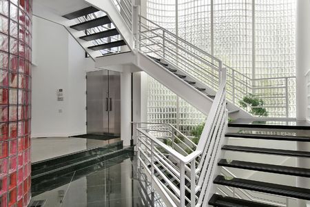 Modern foyer with glass walls and white stairwayの写真素材