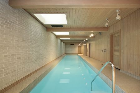 Long indoor swimming pool with wood ceiling beamsの写真素材