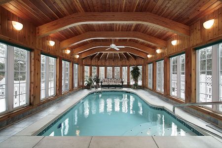 Swimming pool in luxury home with wood ceiling beamsの写真素材