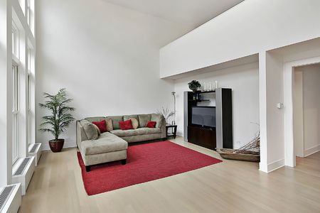 Family room in luxury condominium with two story windowsの写真素材